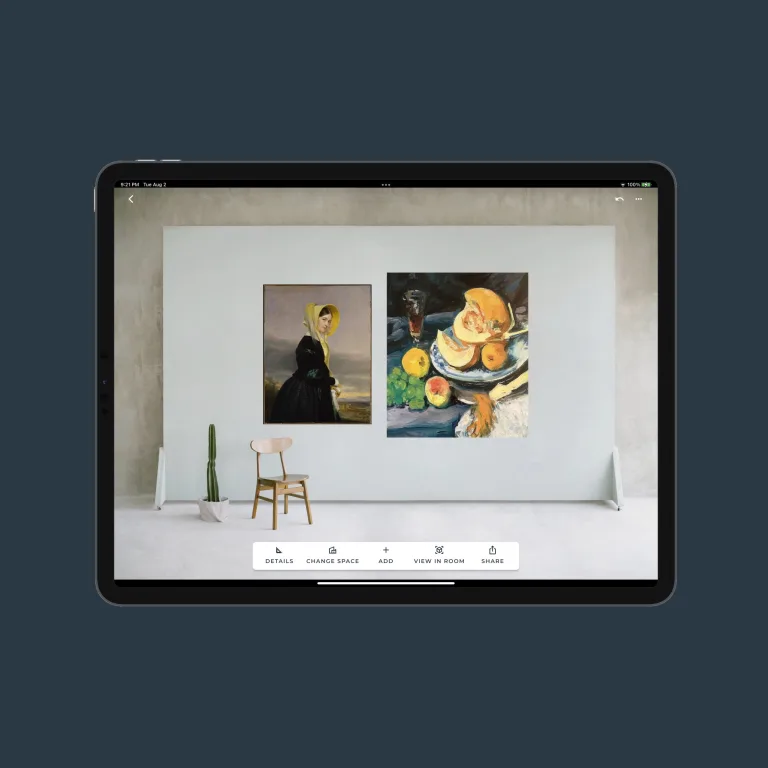 Design view of the Width by Height app on an iPad showing two artworks arranged on a wall with a small chair in the corner to provide size context. There are controls for modifying the design shown on the bottom.