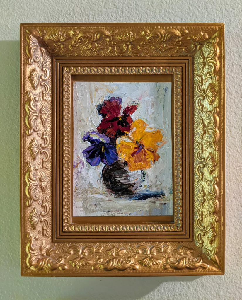 Painting of flowers in a gold frame
